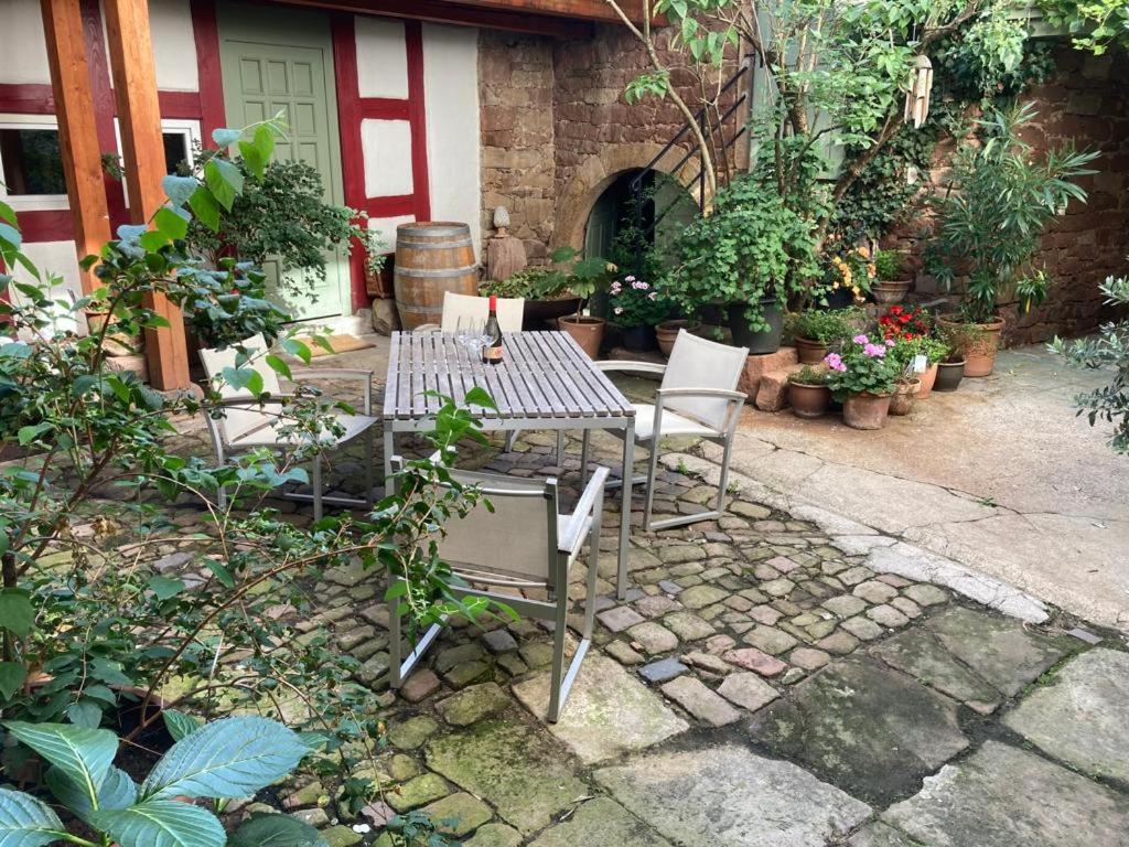 Sitzplatz im Innenhof mit Fass und grüner Tür